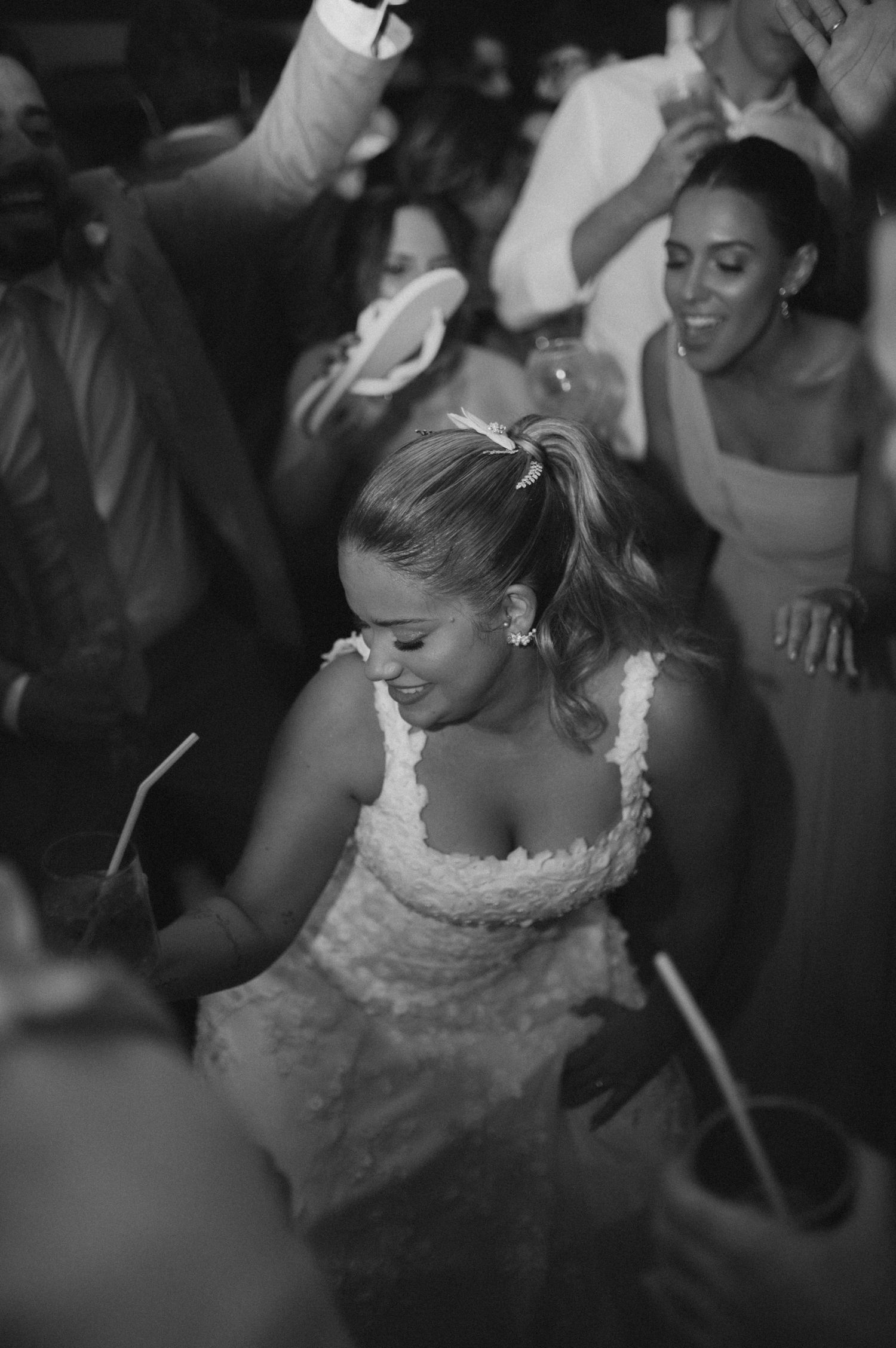 A black and white photo of a bride dancing and enjoying her wedding reception.