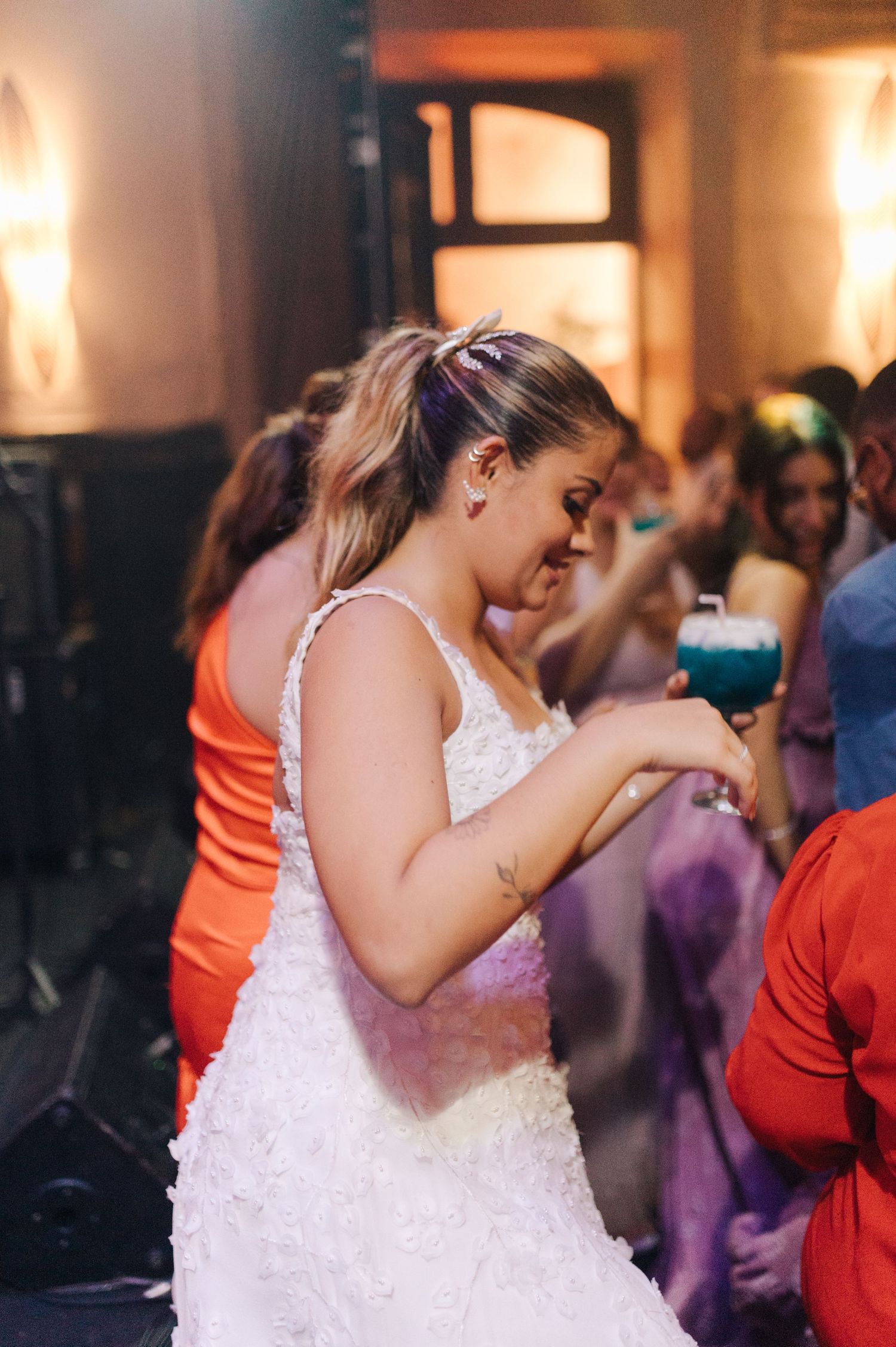 Side view of person in white lace dress checking phone during celebration party.