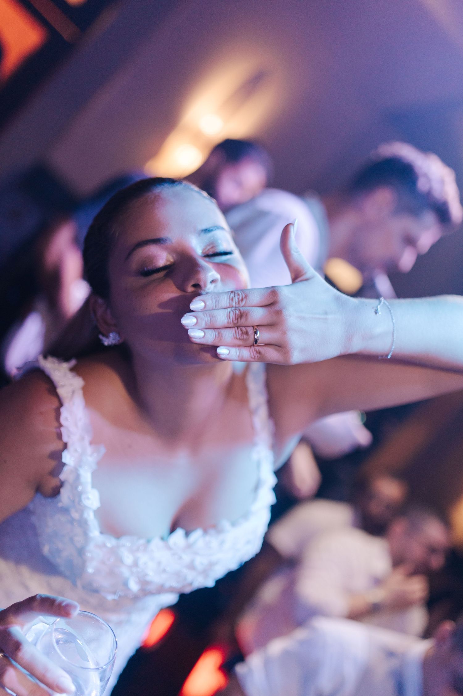 Person in white dress dancing with eyes closed during celebration.