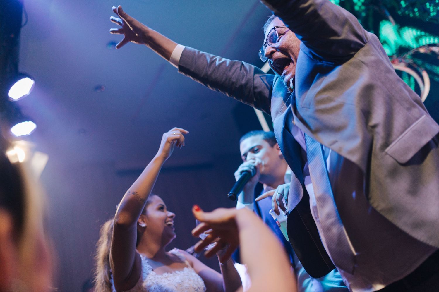 People dancing and reaching upward during energetic celebration.