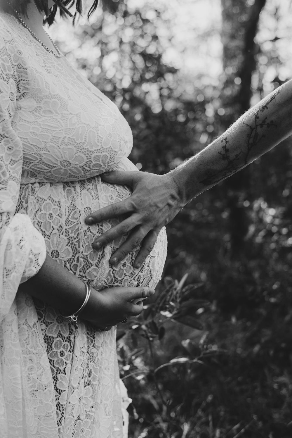 Delicate lace maternity gown detail in black and white photography.