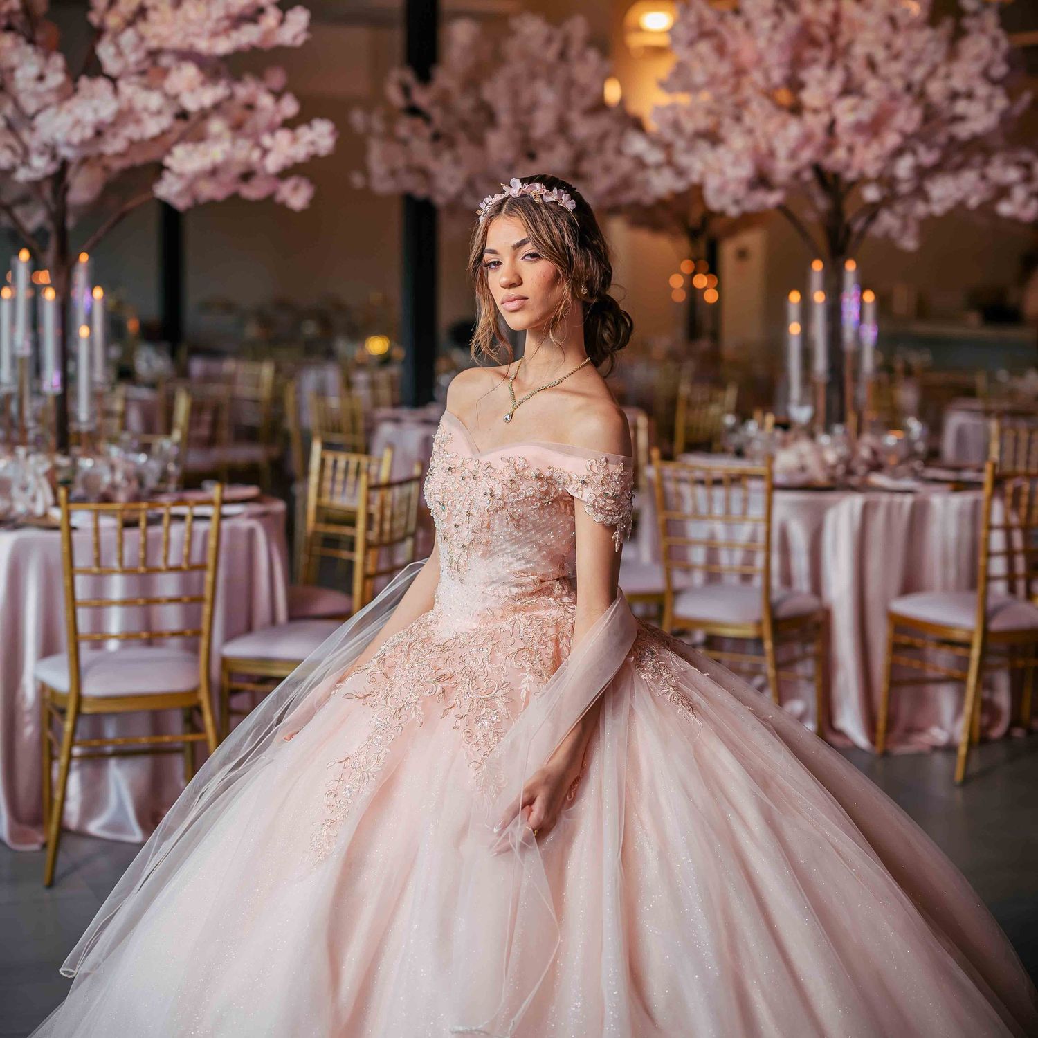 Pink floral ballgown with off-shoulder design in an elegant venue with cherry blossom decorations.