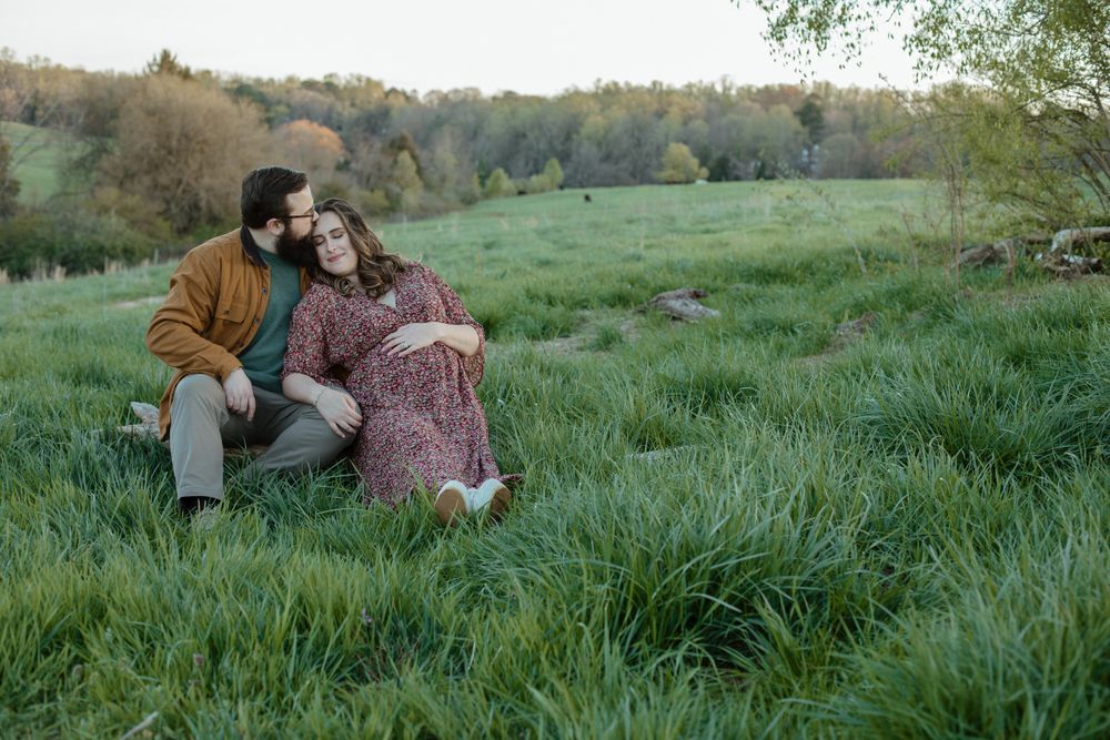 A romantic couple's photoshoot in a lush green meadow during golden hour.