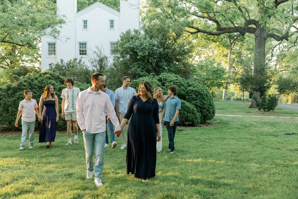 People walking through a lush green garden setting during an outdoor event.