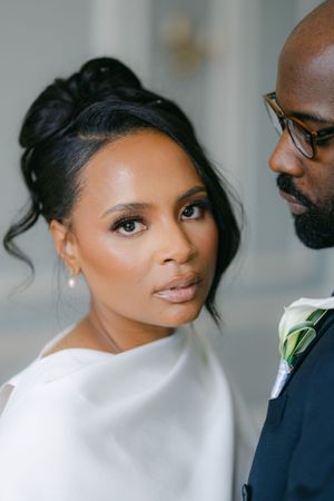Intimate wedding portrait showing couple in elegant white and navy attire with soft lighting.