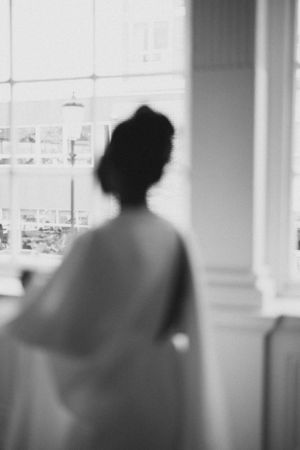 Artistic blurred silhouette of person in flowing white cape dress.
