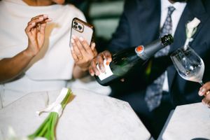 Candid moment of couple celebrating with champagne and calla lilies at wedding.