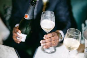 Champagne glasses being held during a celebration toast with blurred hands.