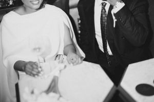 Black and white photo of hands holding glasses at a formal event.