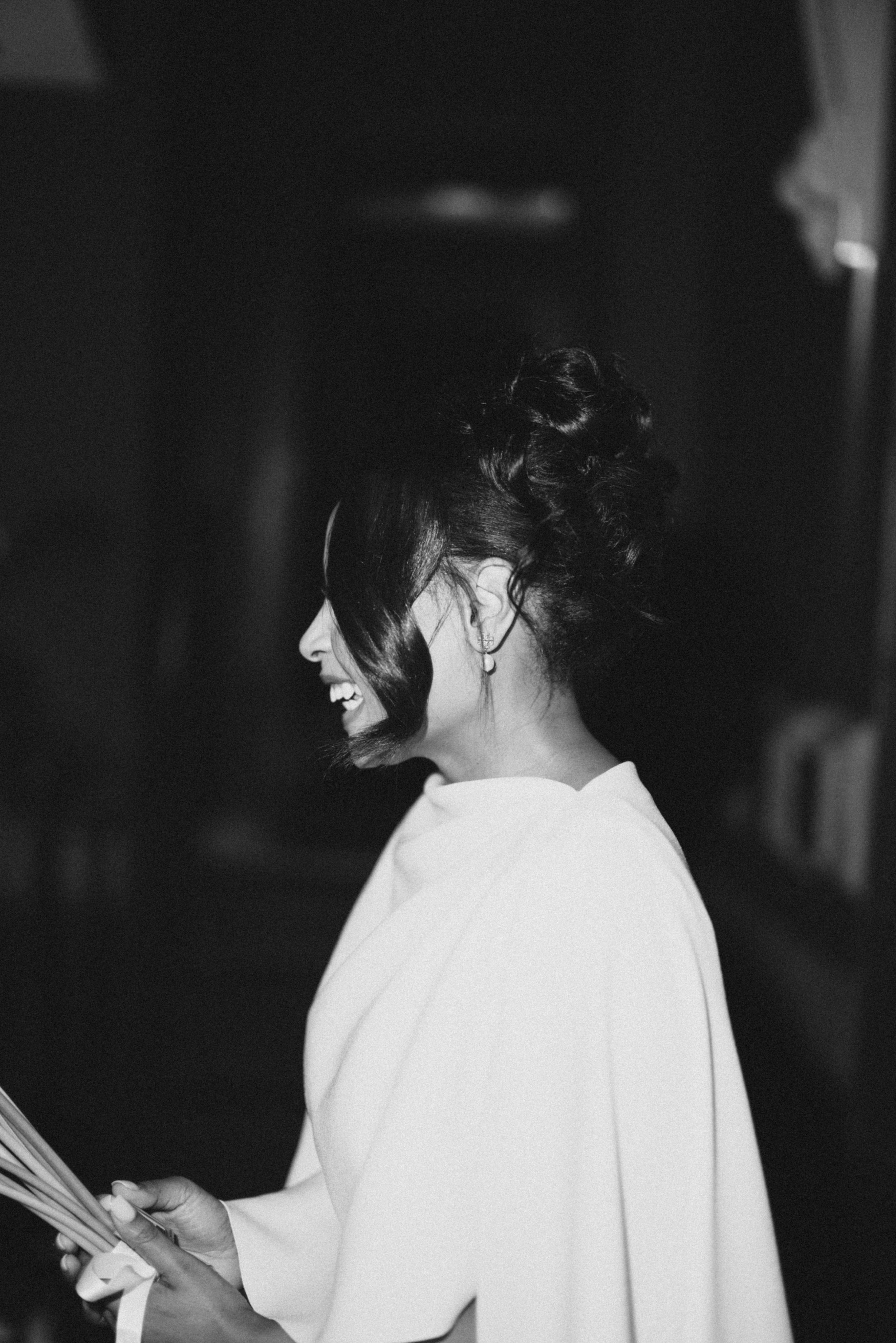 Black and white profile shot of bride with elegant updo hairstyle.