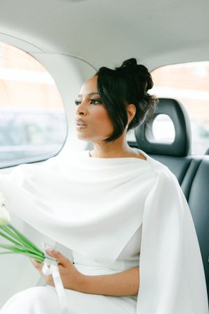 Elegant white dress photographed in car backseat with natural lighting.