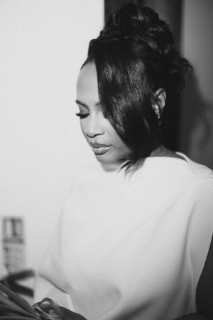 Black and white portrait showing elegant updo hairstyle and white clothing.