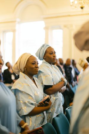Attendees in matching blue and white outfits worship during a church service.