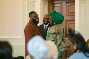 Guests in formal attire conversing during social gathering.