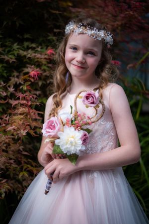 Garden portrait featuring white floral crown and pink roses against red maple leaves.