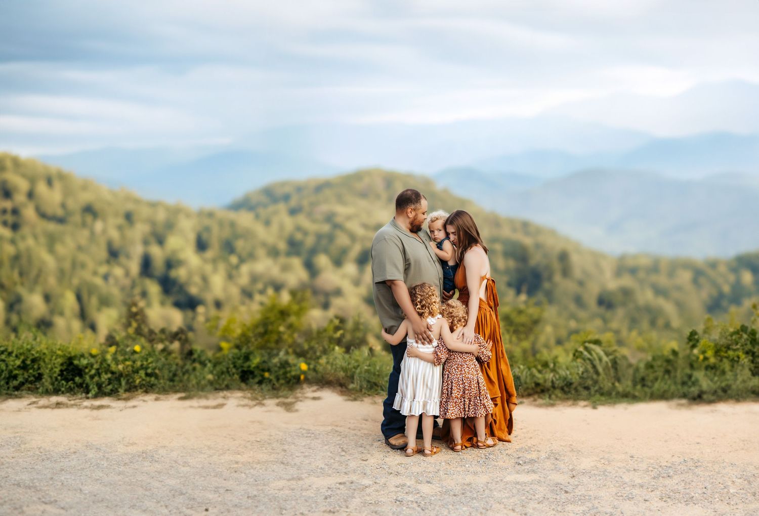 Family of five sharing a cozy group hug on Foothills Parkway in the Smoky Mountains.