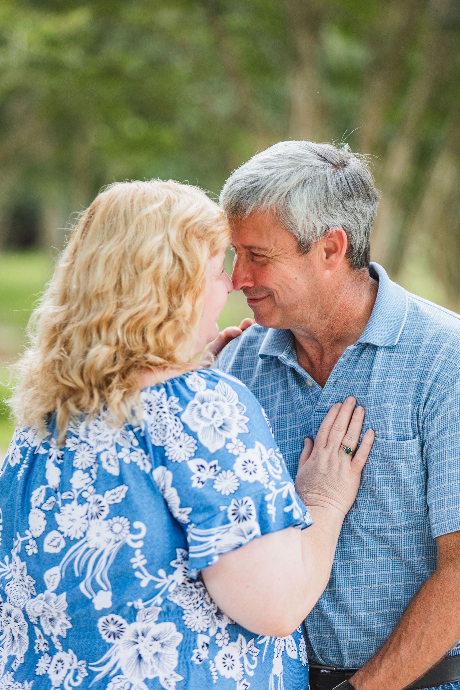 Intimate close-up of couple sharing romantic moment in lush garden setting.