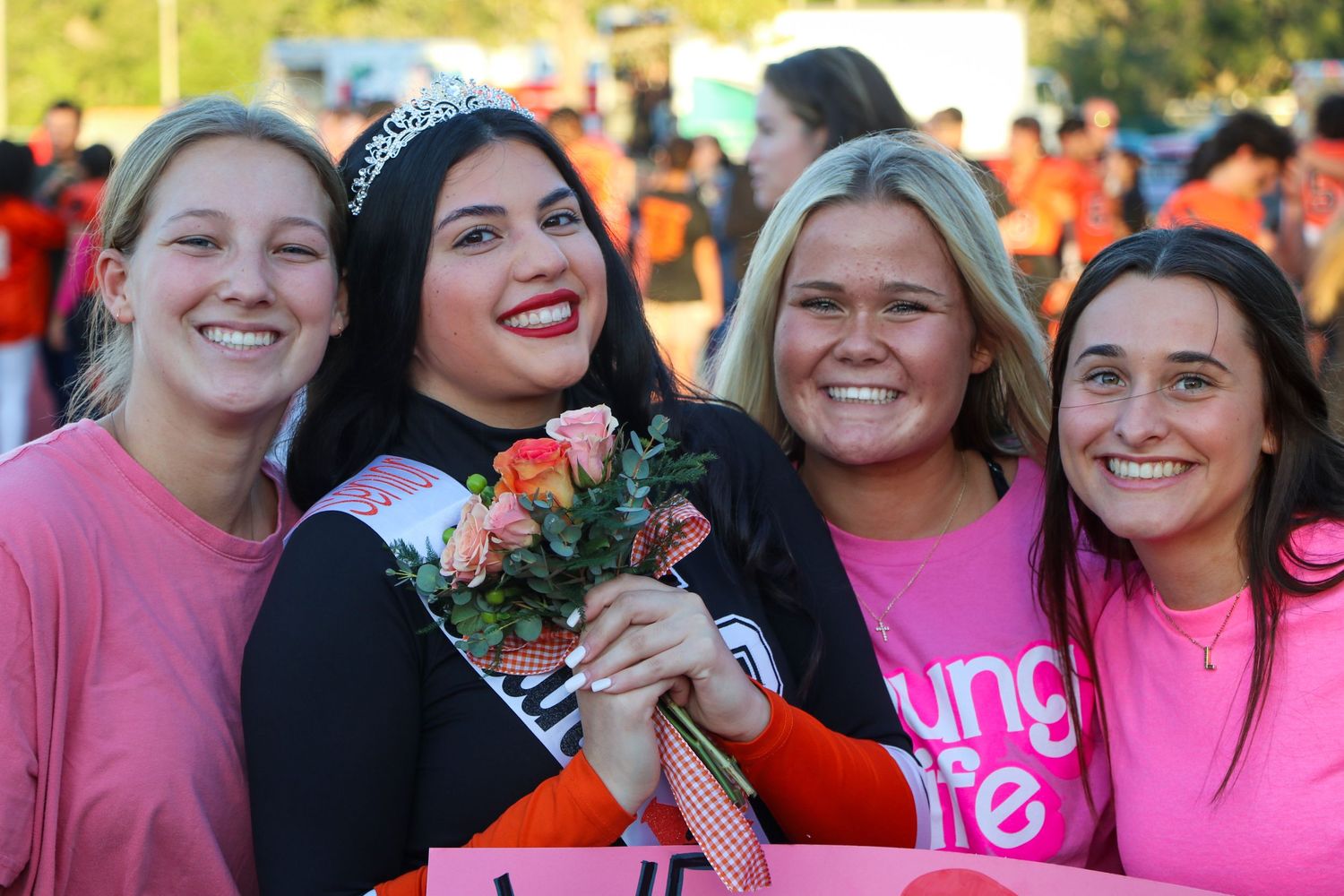 Group wearing pink shirts gathering outdoors for a breast cancer awareness event.