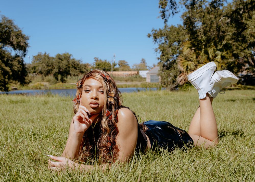 Person lying in a grassy field on a sunny day enjoying nature and relaxation.