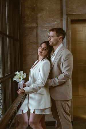 Intimate moment shared between couple near ornate window architecture.