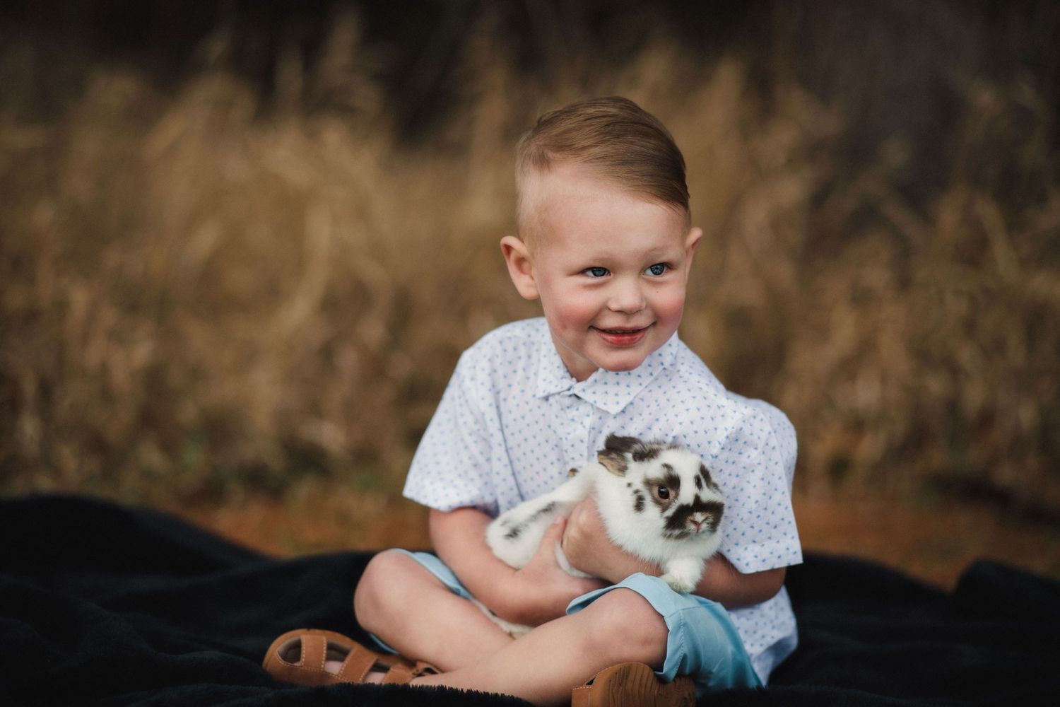 "Smiling child holding a real bunny photographed in Nebraska."