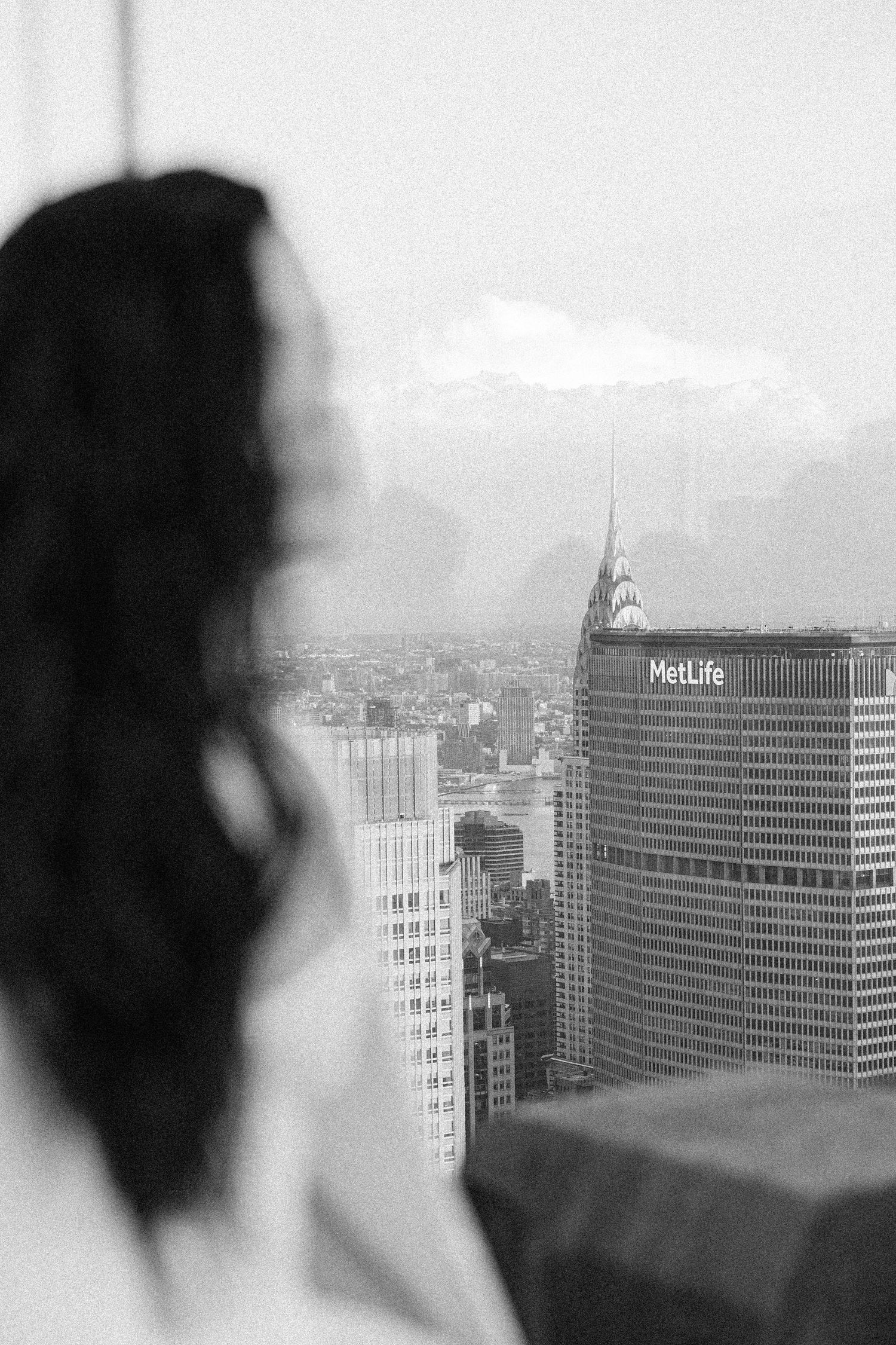 Black and white cityscape view with MetLife building visible through window.