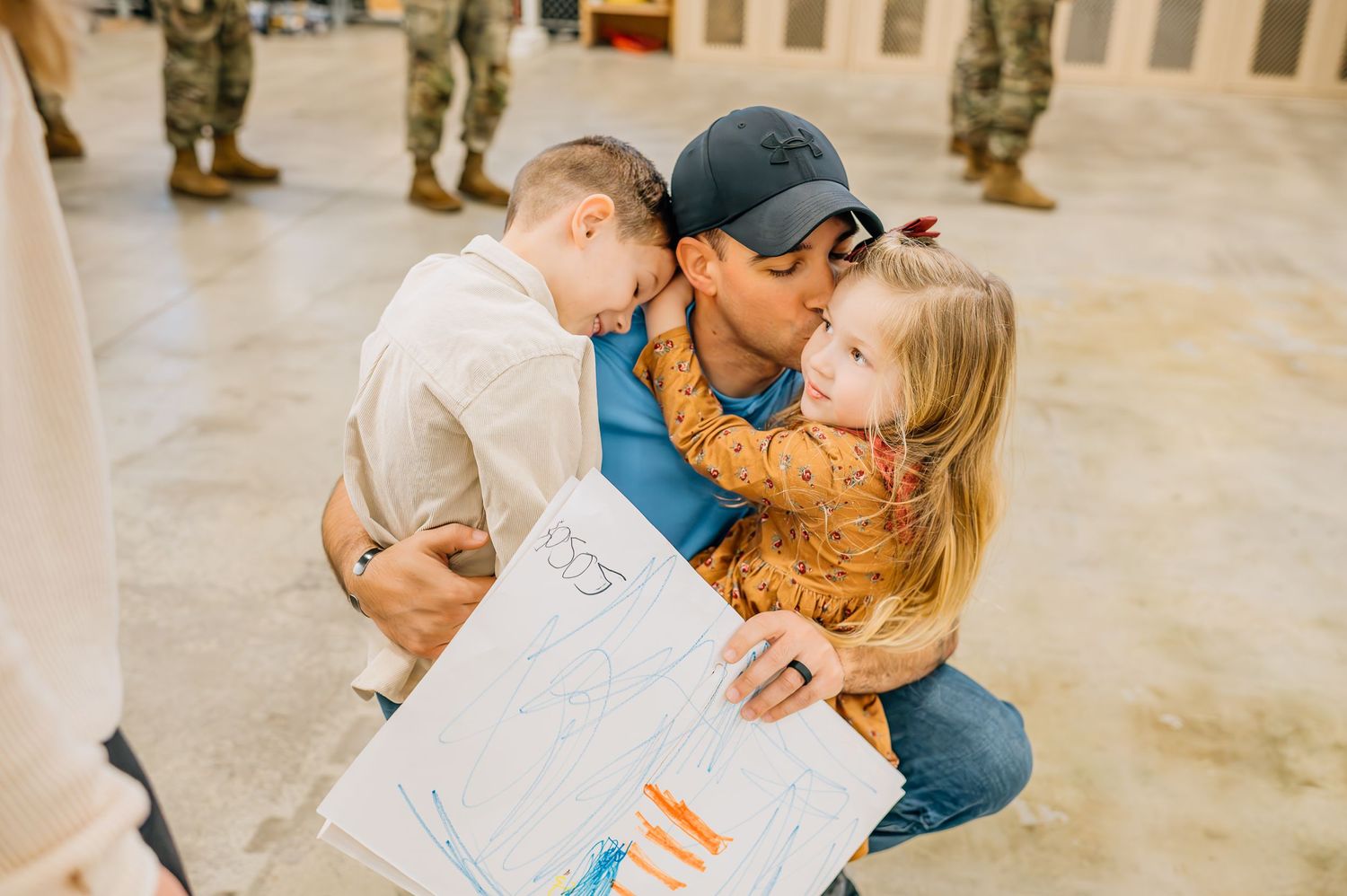 Military homecoming scene with family sharing emotional moment together.