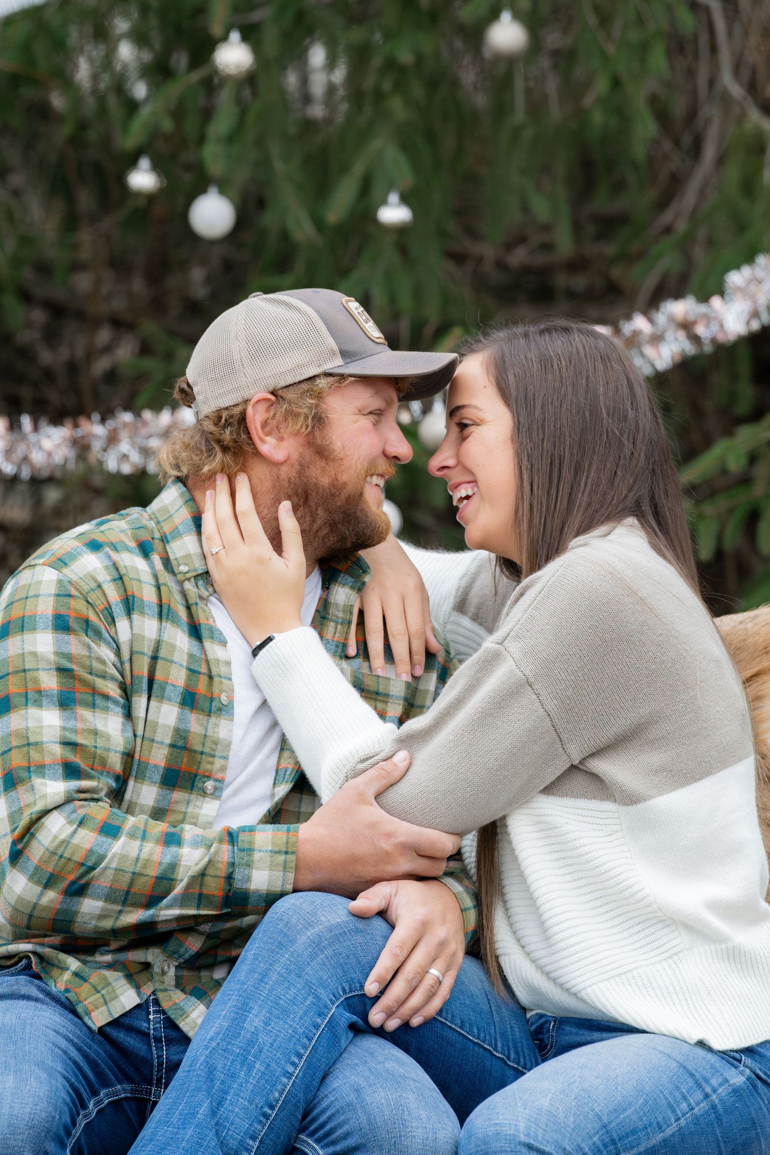 Couple sharing intimate moment outdoors with string lights in background.