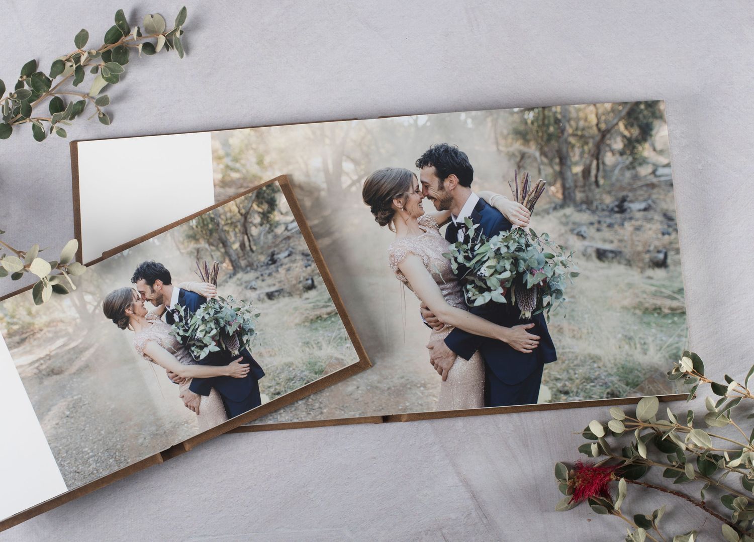 Two wedding photos displayed with eucalyptus leaves on a light gray background.