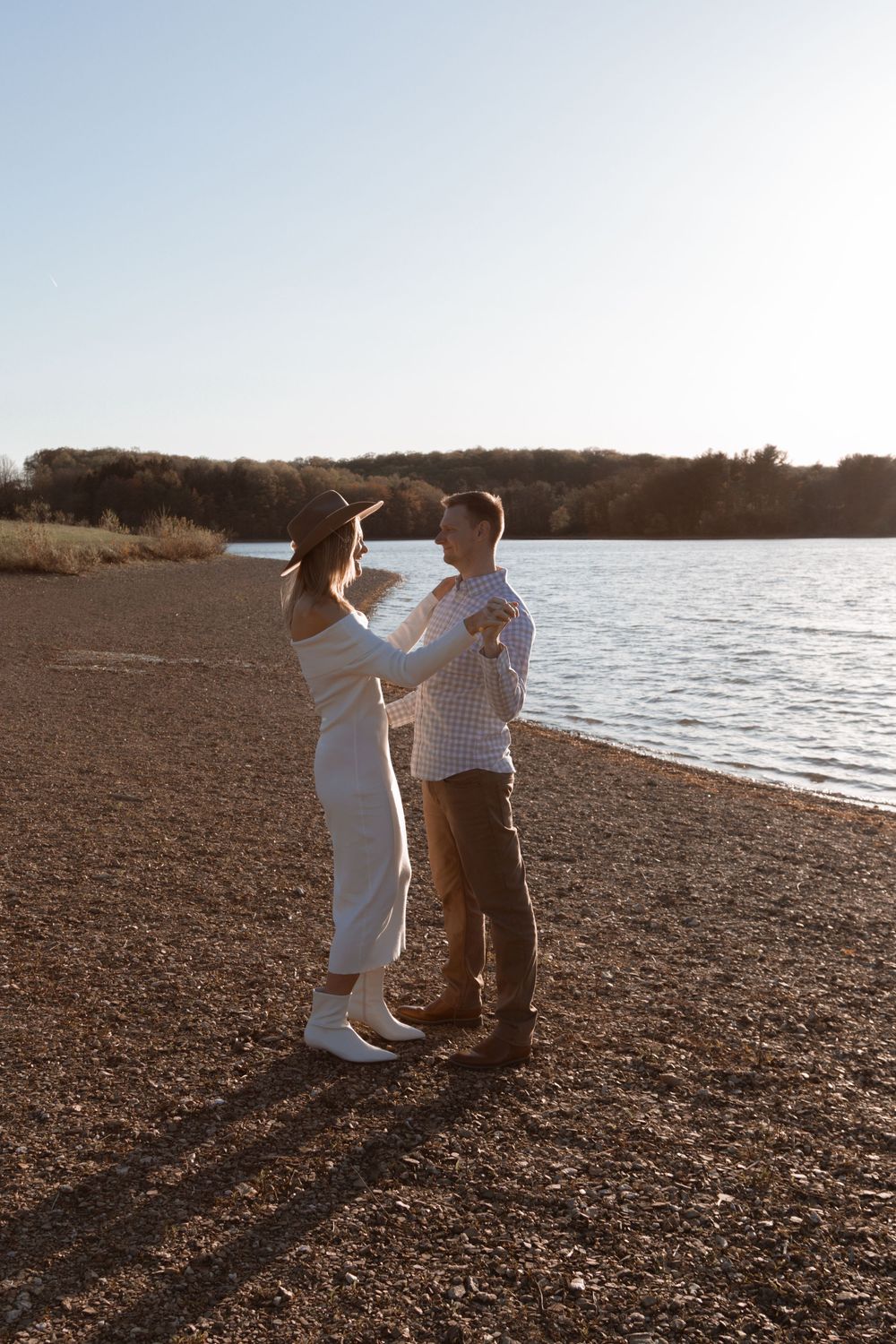 Dancing couple shares an intimate moment on the shoreline at sunset.