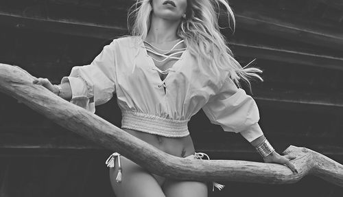 Black and white fashion photo with cropped white blouse and windswept styling.