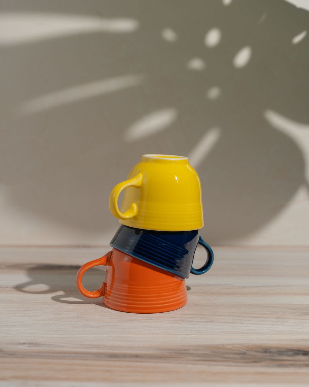 Three Fiesta coffee cups stacked on a table