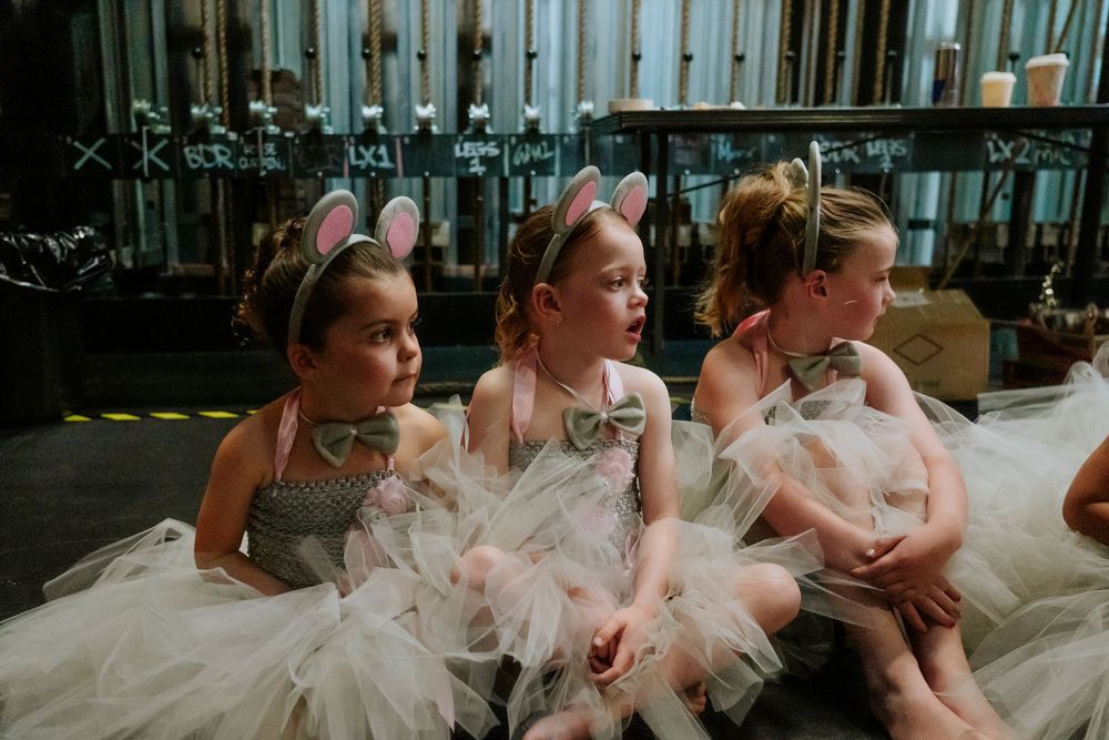 reportage photo en coulisses de spectacle de danse, photos backstages derrière les rideaux, groupe de tross petites danseuses.