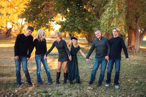 Family holding hands in line among autumn trees in Southern Utah