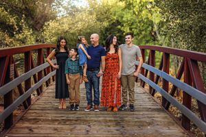 A group poses together on a wooden bridge surrounded by lush greenery in Southern Utah