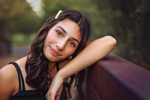 Portrait of a woman with dark hair resting against a rustic background in natural lighting in Southern Utah