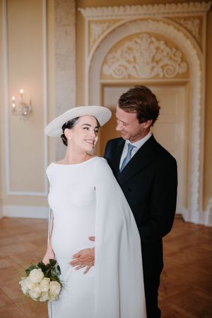 Elegant couple gazes at each other lovingly in a formal ballroom setting during their wedding.