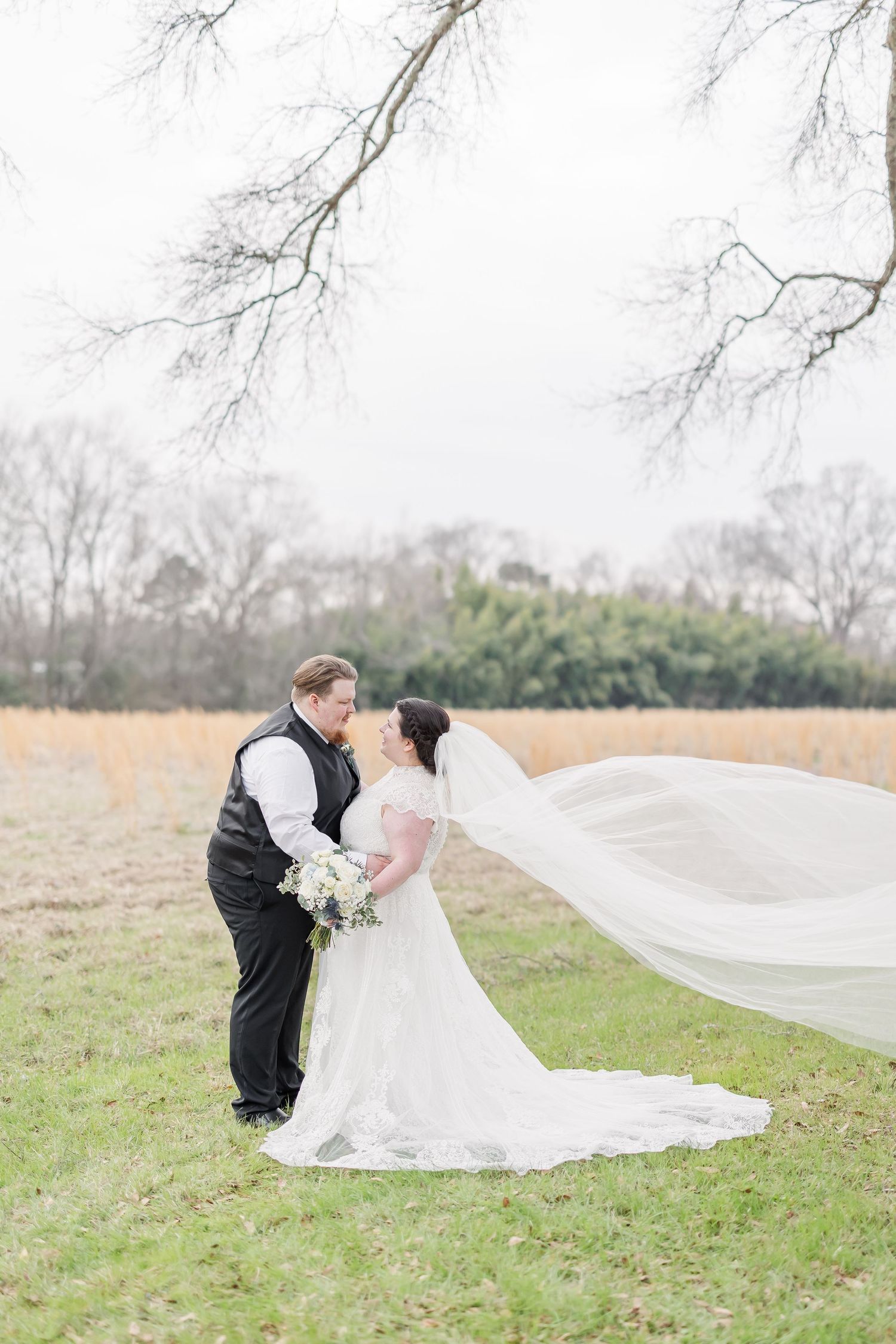 Delicate white and peach wedding bouquet with roses and greenery.