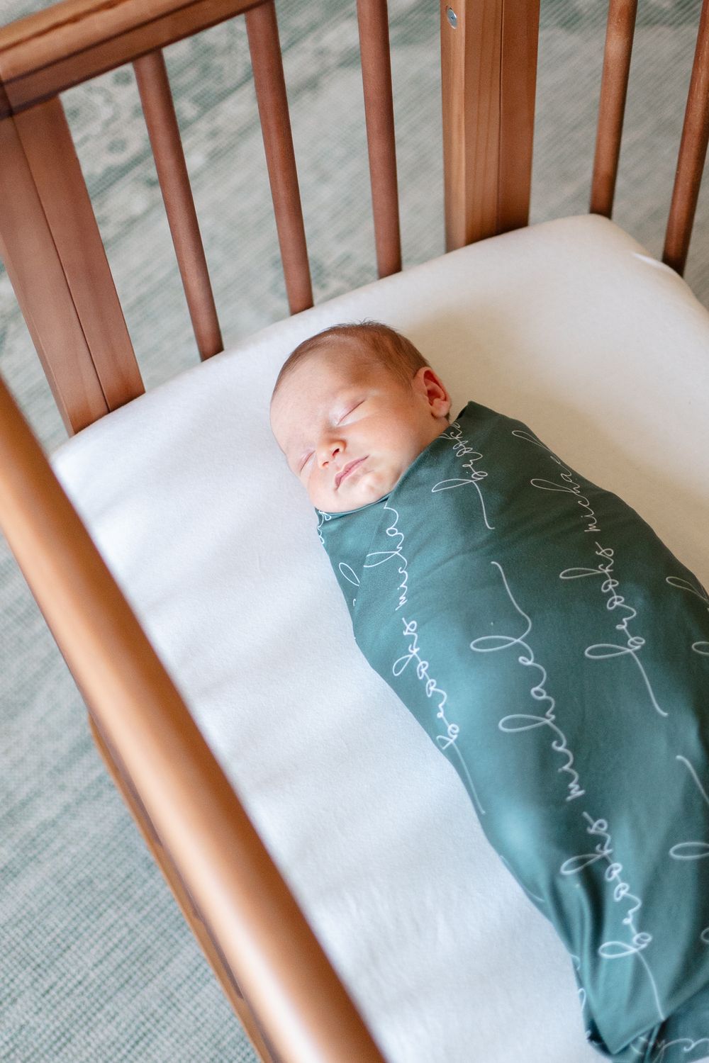 Newborn baby sleeps peacefully during the lifestyle newborn shoot at home.