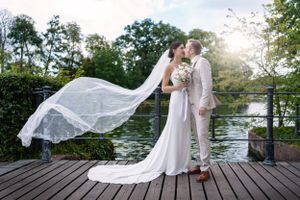 Hochzeit fotos in Berlin - Bräutigam küsst die Braut, Schleier fliegt im Sonnenuntergang. Best Hochzeitsfotograf Berlin