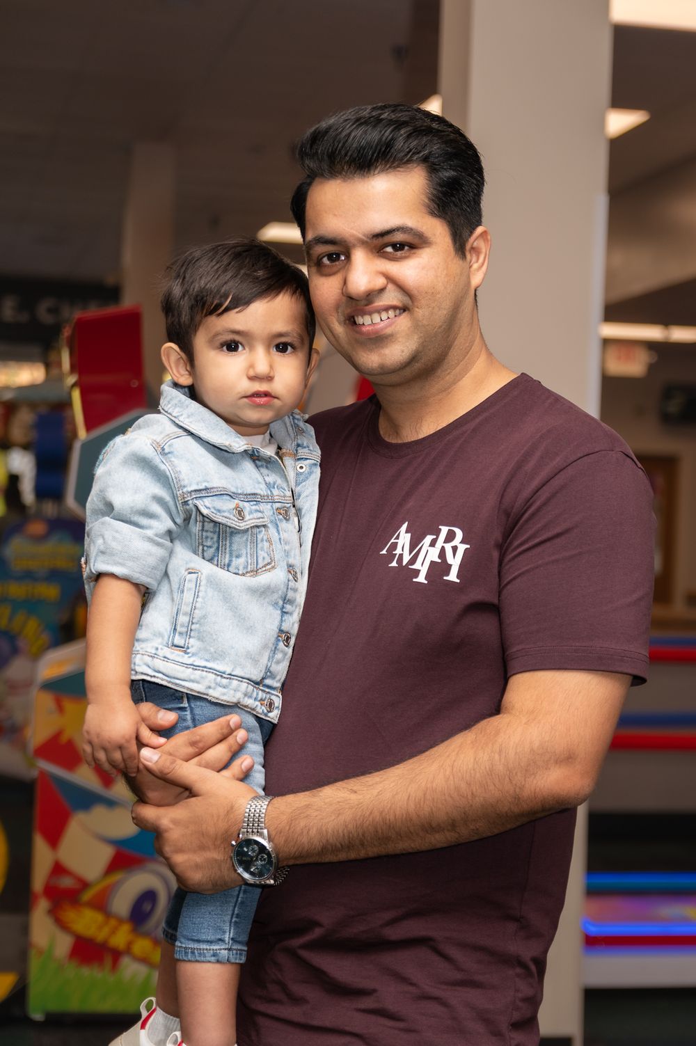 Parent and child sharing tender moment in indoor play area setting.