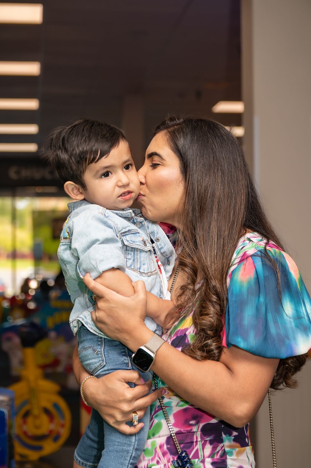 Tender moment shared between parent and child in indoor play area.
