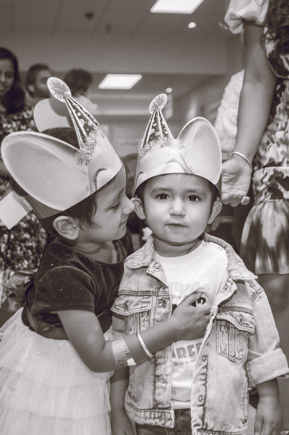 Two children wearing mouse ear party hats at a celebration.