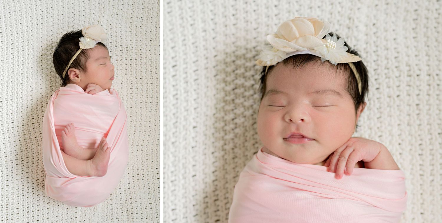 Newborn baby sleeping peacefully in pink wrap and delicate headband.