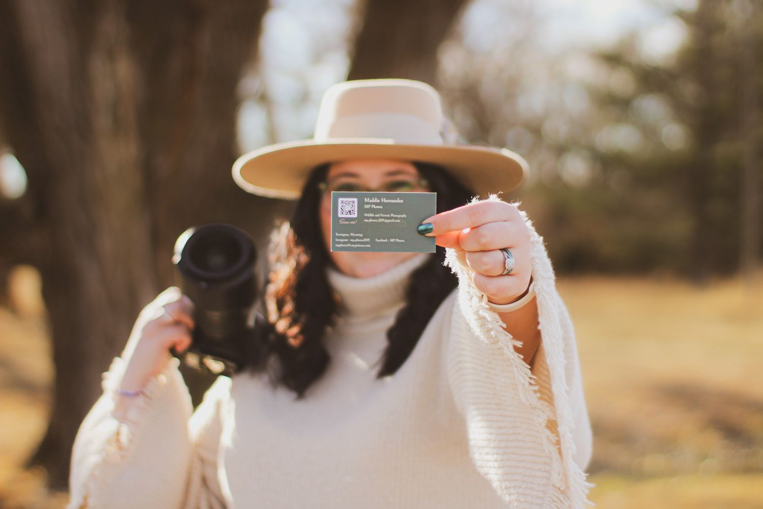 Photographer with camera in sunflower field wearing dark shirt and baseball cap.
