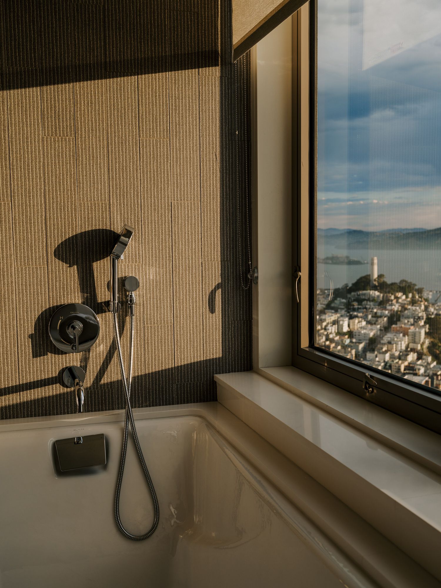 Modern bathroom shower with window view overlooking Coit Tower and San Francisco Bay at the Four Seasons Embaracdero property.