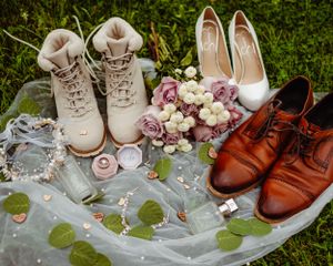 Wedding shoes arrangement featuring combat boots, white heels, brown oxfords and pink roses.