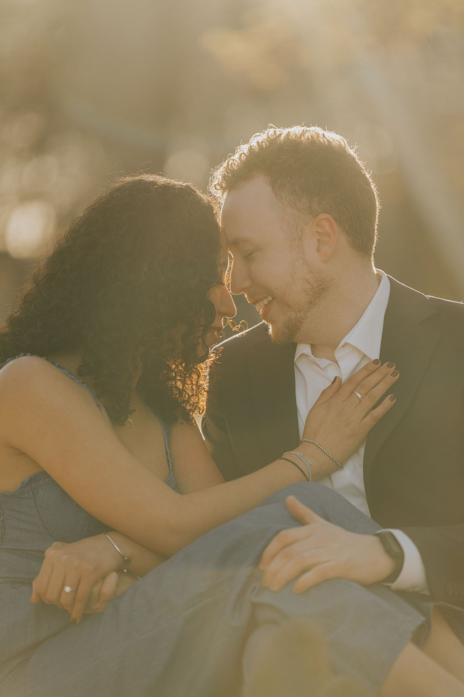 Romantic portrait of a couple in golden sunlight sharing an intimate moment.