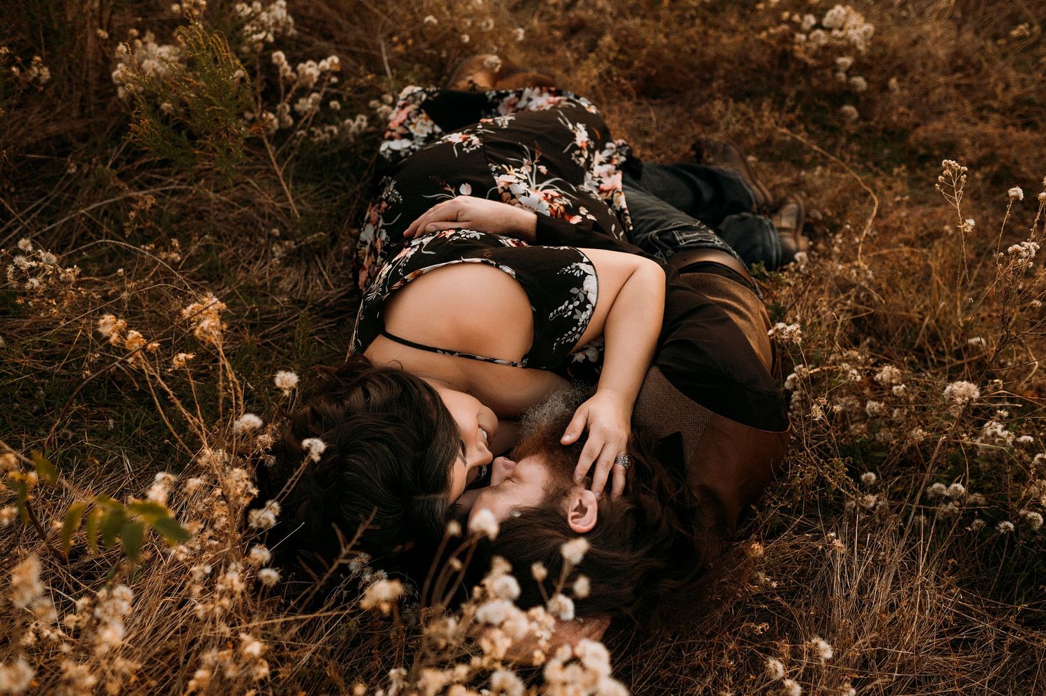 romantic couple cuddle in a field