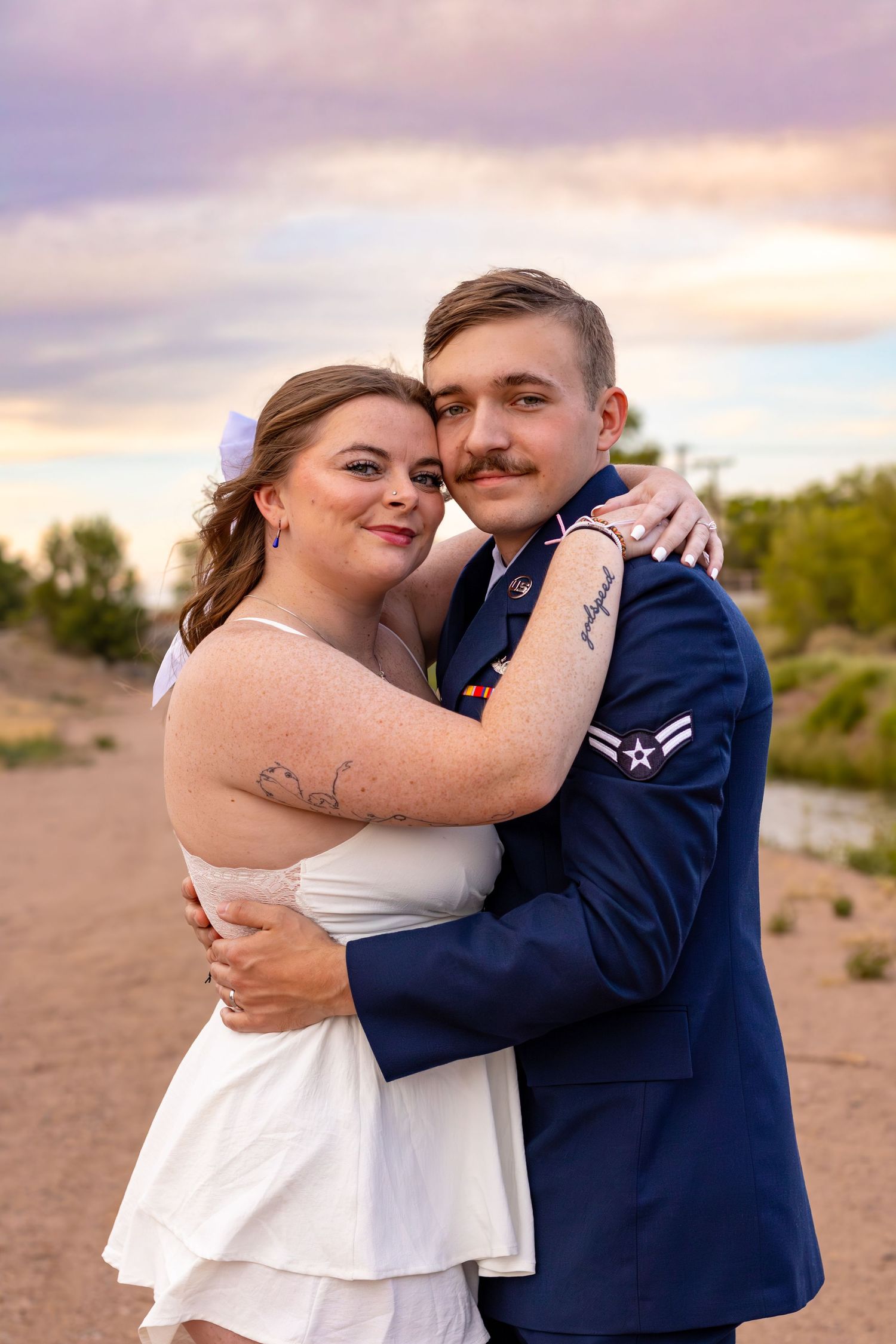 Newlywed couple embraces during sunset desert photoshoot.